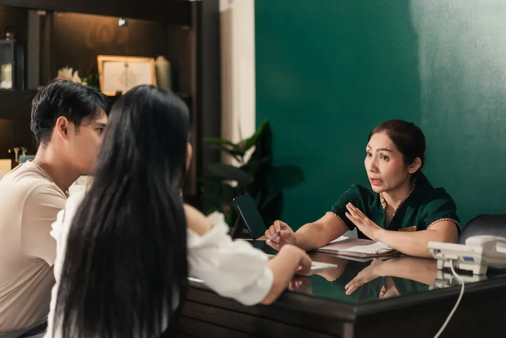 Asian Woman Spa Receptionist Aider un client à sélectionner et présenter le forfait massage.