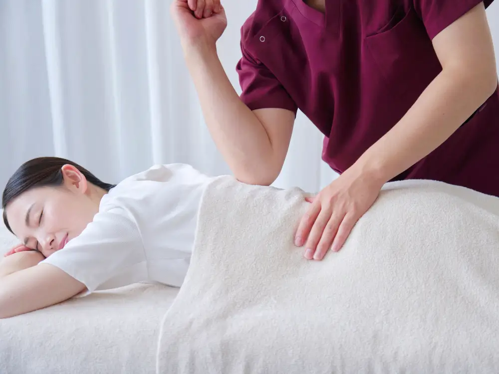 Femme asiatique recevant un massage d'un massothérapeute.