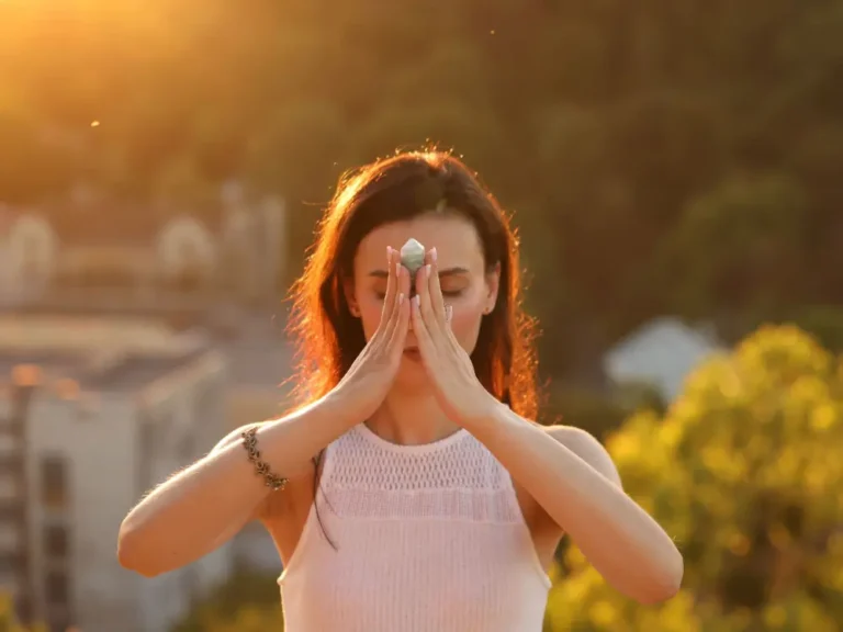 Femme méditant avec du cristal pour guérir ou restaurer son aura à l'extérieur.