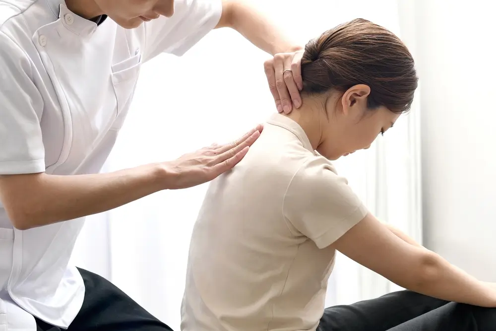 Un homme donnant un massage à une patiente.